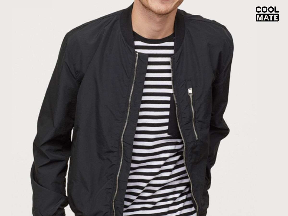 Áo bomber jacket màu đen, lộ rõ phần khóa kéo và phần cổ bo chun
