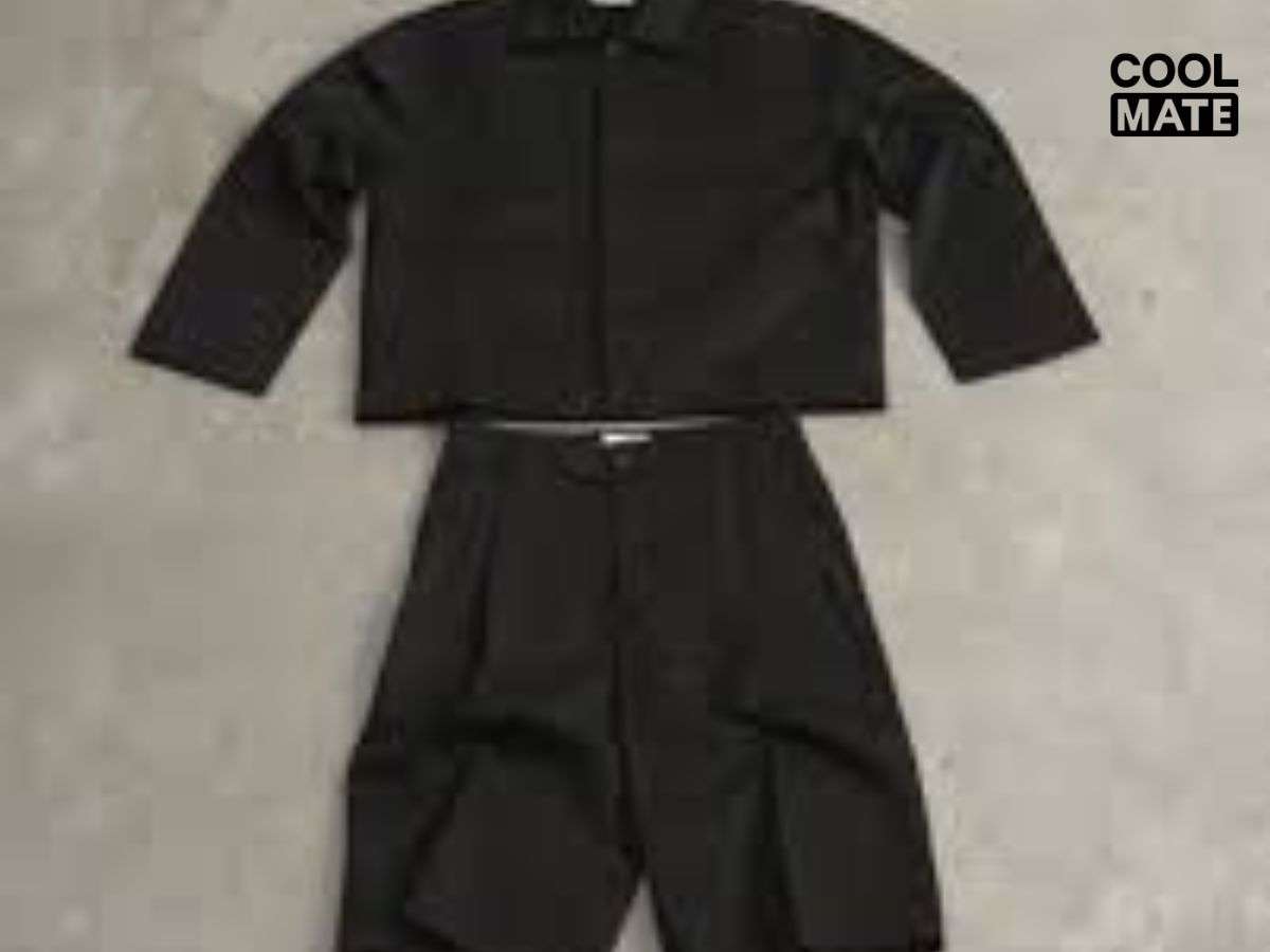 Phong cách Black-on-Black với sơ mi và quần short đen tạo vẻ nam tính, mạnh mẽ, bí ẩn, thêm phụ kiện như đồng hồ kim loại và kính râm để hoàn thiện.