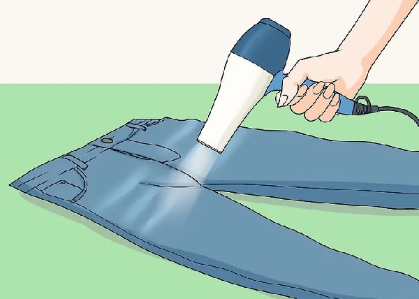 Sử dụng máy sấy để làm nóng và kéo giãn quần jeans