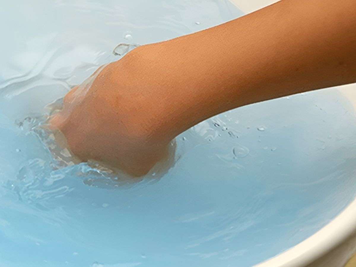 Pha loãng nước giặt với nước ấm rồi cho áo vào