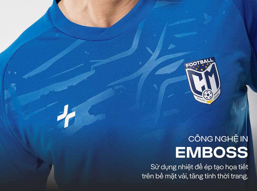 Cận cảnh họa tiết in Emboss trên thân áo và logo Football Club CM trên ngực áo bóng đá cổ tròn CFA24 màu xanh