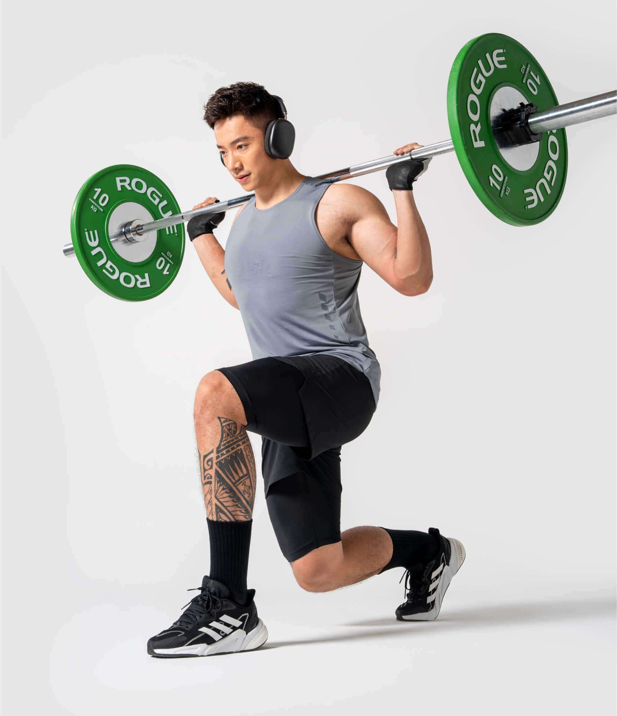 Người mẫu nam mặc tất thể thao cổ dài Coolmate kết hợp cùng trang phục gym đang thực hiện bài tập lunge với tạ