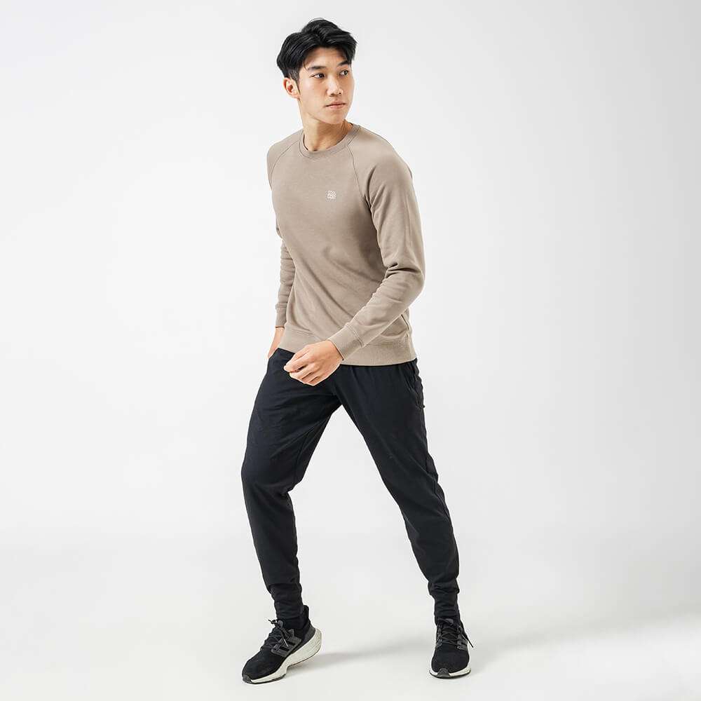 Người mẫu nam phối đồ với áo Sweatshirt Active màu nâu và quần jogger đen