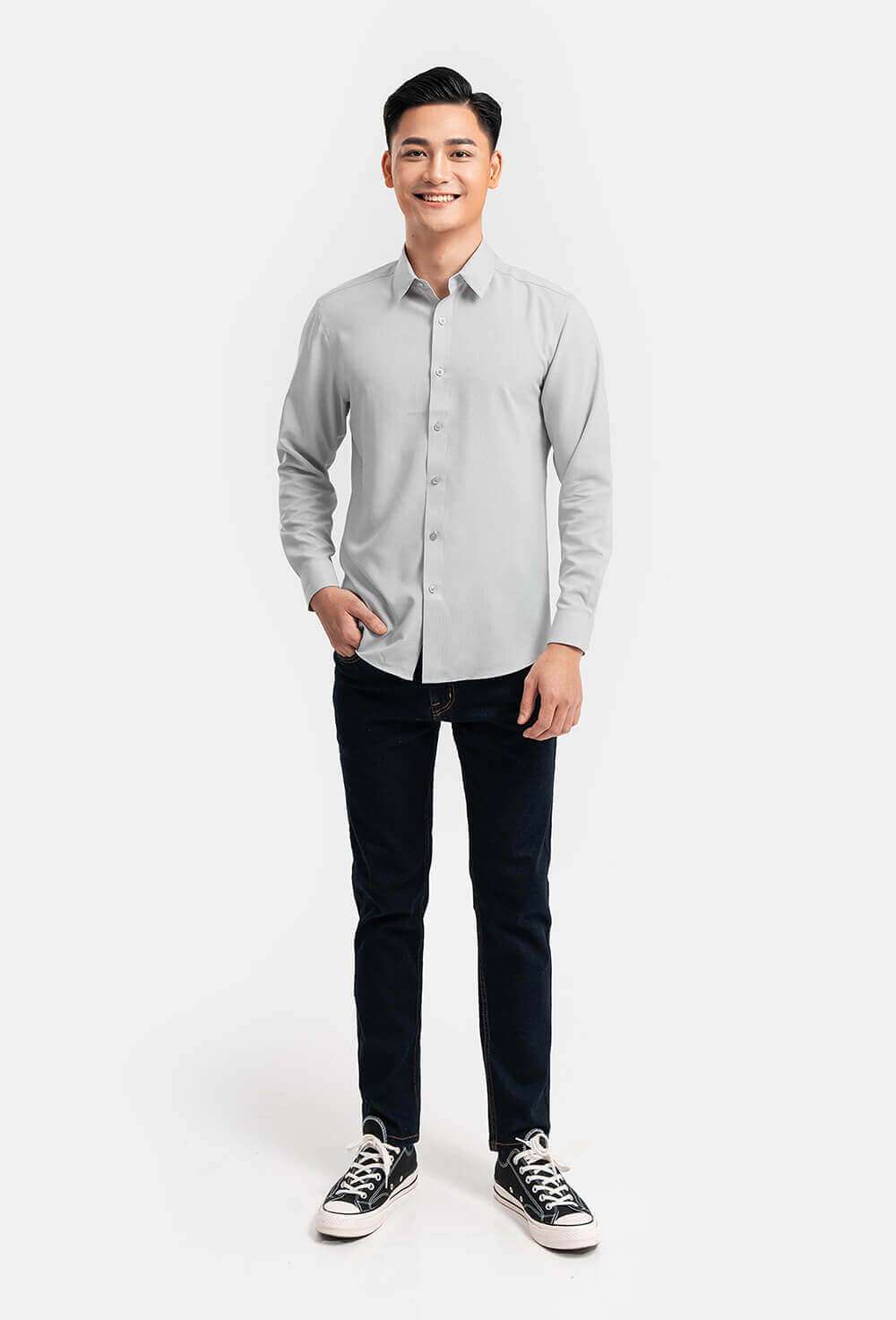Người mẫu nam mặc áo sơ mi Café-DriS màu xám cùng quần jean và giày sneaker, chụp toàn thân