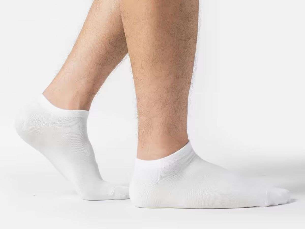 Người mẫu mang đôi vớ cổ ngắn nam Cotton Basics màu trắng làm từ 100% cotton, mềm mại và thấm hút mồ hôi tốt